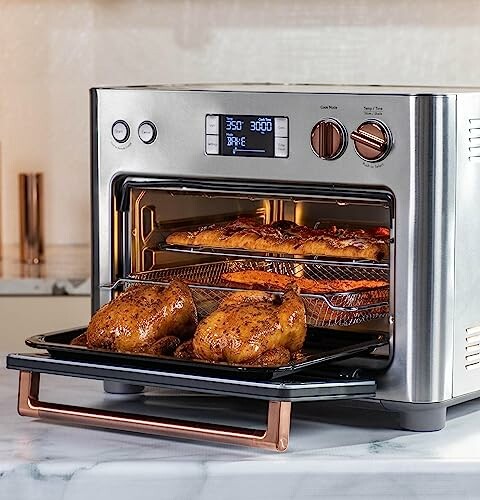 Countertop oven with roasted chicken and ribs inside.