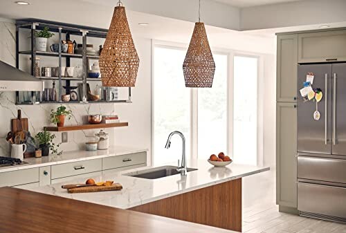 Modern kitchen with island, wicker pendant lights, and stainless steel fridge.